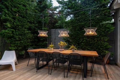 a wooden table and chairs on a patio with lights at The Mansion - Kalamata Mediterranean Villas in Kalamata
