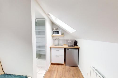 une petite cuisine avec un évier et un micro-ondes dans l'établissement Studio Coty 2èmeG, au Havre