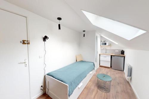 une chambre avec un lit dans une pièce blanche dans l'établissement Studio Coty 2èmeG, au Havre