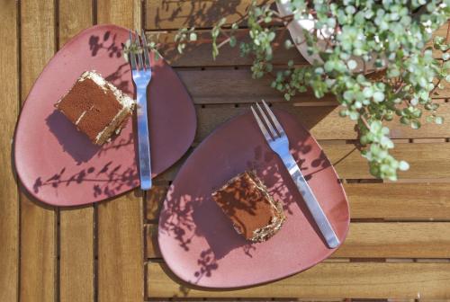 two pink plates with a piece of cake and a fork at Haha Familjesol in Gothenburg