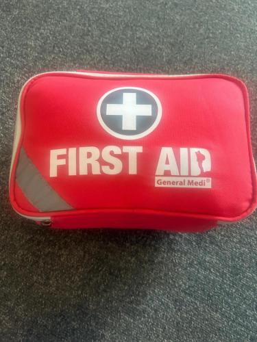 a red first aid container with the first aid logo on it at Modern well kept home- Entire House in Abercynon