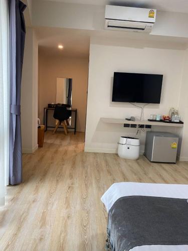 a bedroom with a bed and a flat screen tv at Tisa Hotel Udonthani in Udon Thani