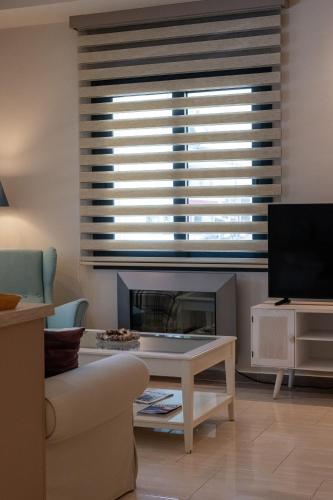 a living room with a fireplace and a large window at The Mansion - Kalamata Mediterranean Villas in Kalamata