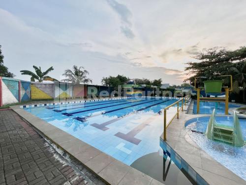 a large swimming pool with chairs in it at Lafa Park Syariah Rengas Bandung Cikarang Redpartner in Glonggong