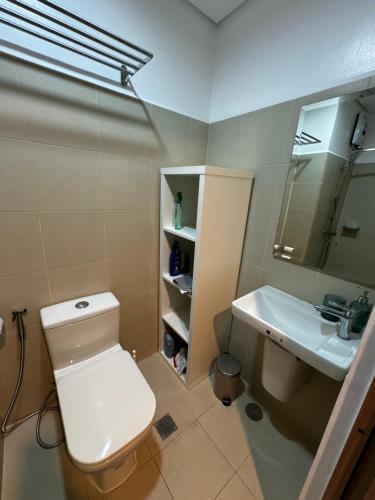 a bathroom with a white toilet and a sink at Makati apartment - Lush Residences in Manila