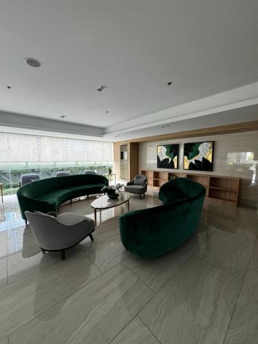 a living room with green furniture in a building at Makati apartment - Lush Residences in Manila