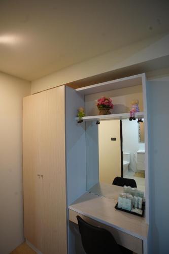 a room with a desk and a mirror in a room at Tisa Hotel Udonthani in Udon Thani