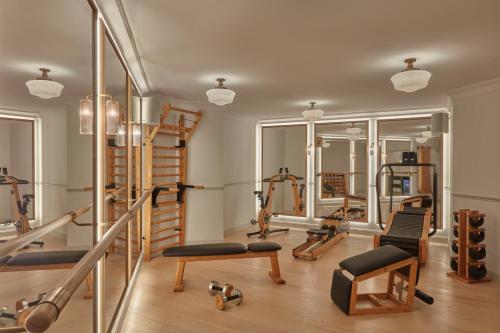 a gym with treadmills and exercise equipment in a room at Miiro Le Grand Hôtel Cayré in Paris