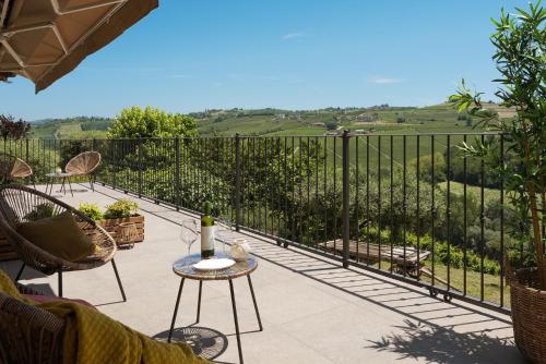 a patio with a table with a bottle of wine at Casa di Pina - Iris - Dalia in Monforte dʼAlba