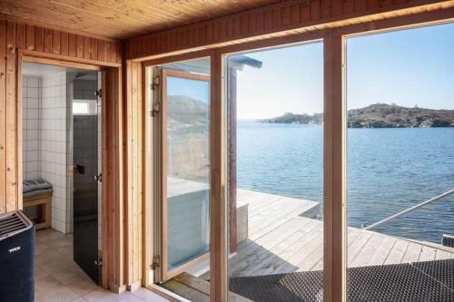 a house on the water with sliding glass doors at House for 6 with Breathtaking Sea Views - 35 min from Gothenburg in Kärna