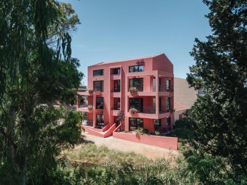 a pink building with trees in front of it at AKTI SEASIDE SUiTES in Preveza