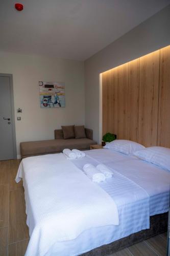 a bedroom with a large white bed and a couch at RiA BLU DELUXE HOTEL in Neos Marmaras