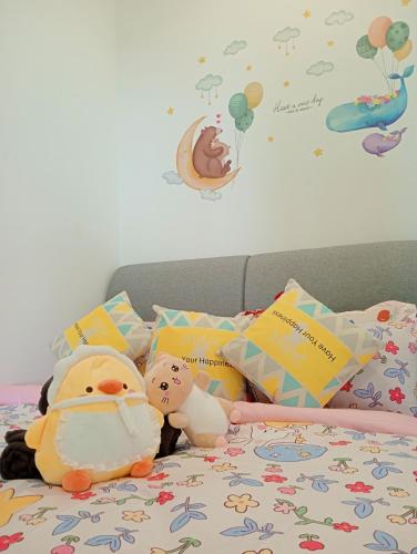 a bed with stuffed animals and pillows on it at Legoland walk 3min D'Pristine Rejoice Suite 2B2R 8pax Lakeview in Nusajaya