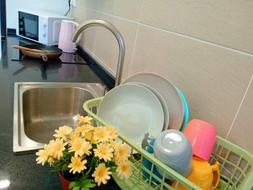 a kitchen counter with a sink with dishes and flowers at Legoland walk 3min D'Pristine Rejoice Suite 2B2R 8pax Lakeview in Nusajaya