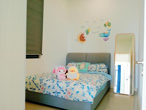 two stuffed animals sitting on a bed in a bedroom at Legoland walk 3min D'Pristine Rejoice Suite 2B2R 8pax Lakeview in Nusajaya