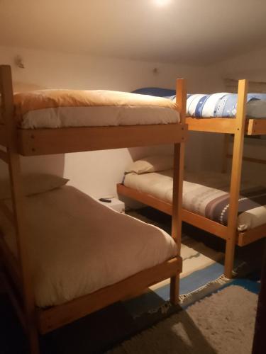 a room with three bunk beds and a chair at casa Wamani in Santiago