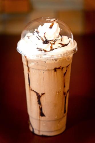 a drink in a plastic cup with whipped cream and chocolate at DCCCO Hotel in Dumaguete