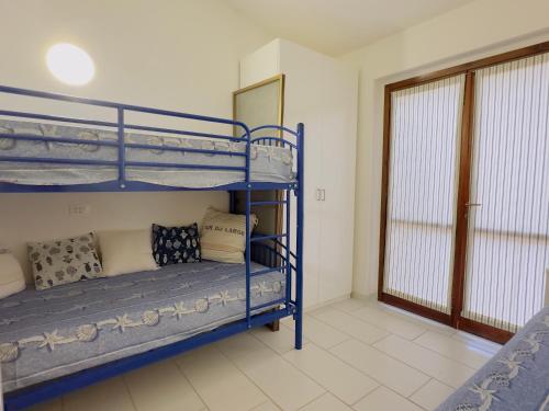 um quarto com dois beliches e uma janela em VILLA FERRATA - A soli 300m dal mare em Costa Rei