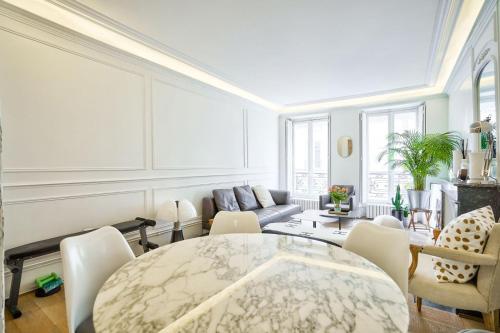 un salon avec une table et des chaises dans l'établissement Trocadéro - Genuine Apartment, à Paris