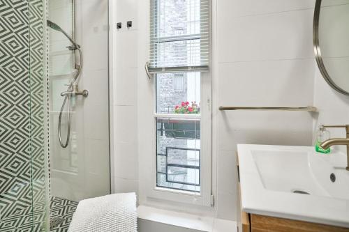 une salle de bain avec une douche et un lavabo et une fenêtre dans l'établissement Trocadéro - Genuine Apartment, à Paris