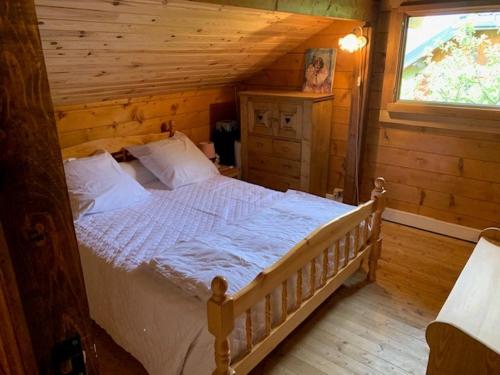une chambre avec un lit dans une cabane en rondins dans l'établissement Appartements Barcelonette by PraLoup Vacances, à Barcelonnette