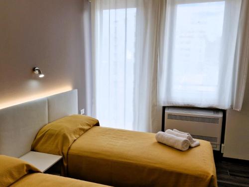 a hotel room with two beds and a window at Medici Alloggi Turistici in Vicenza