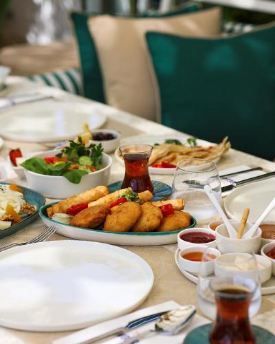 una mesa con platos de comida encima en The Xon Hotel, en Cesme
