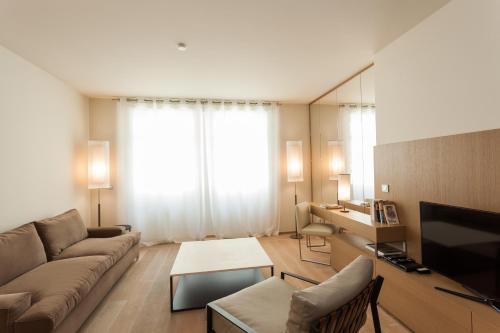 a living room with a couch and a large window at Guillaume Suites in Luxembourg