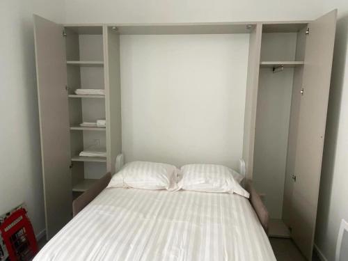 - une petite chambre avec un lit aux murs blancs dans l'établissement VILLA ANGELUS 2 minutes de Monaco, à Beausoleil