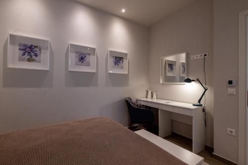 a bedroom with a bed and a desk with a lamp at The Mansion - Kalamata Mediterranean Villas in Kalamata