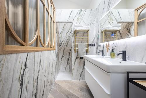 a bathroom with a white sink and marble walls at Villa fleurie in Cagnes-sur-Mer