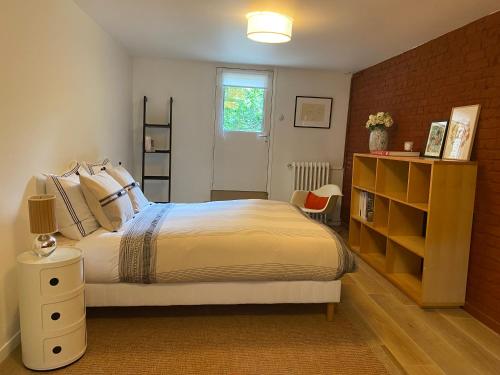 une chambre avec un lit et un mur de briques dans l'établissement Appartement privé avec jardin, à Boulogne-Billancourt