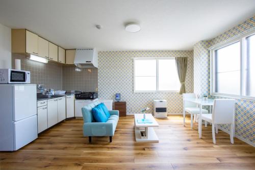 a kitchen and living room with a couch and a table at SharCul Hirosaki 301 in Hirosaki