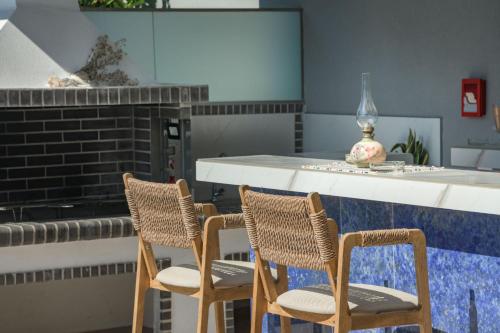 a kitchen with two chairs and a counter at Dareia Suites in Plános