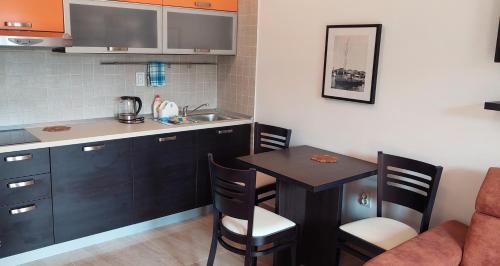 a small kitchen with a table and a sink at Apartments Danilo Kažanegra in Sveti Stefan
