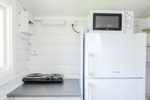 a kitchen with a microwave on top of a refrigerator at Östersunds Camping in Östersund