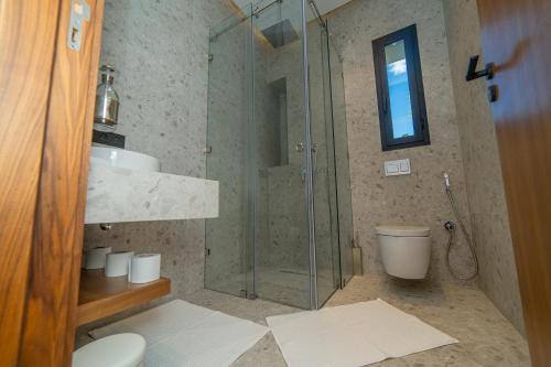 a bathroom with a glass shower and a toilet at Villa Marrakech vue atlas in Marrakech