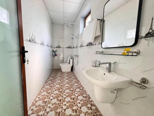 un baño con lavabo e inodoro en Nhà Của Mom, en Buon Ma Thuot