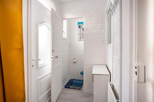 La salle de bains blanche est pourvue d'une douche et de toilettes. dans l'établissement Nid douillet aux portes de Nancy, à Varangéville