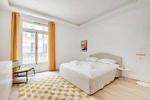 une chambre blanche avec un lit et une fenêtre dans l'établissement Chic flat with garden terrace -4BR-12P - Trocadéro, à Paris