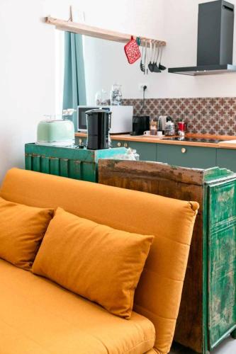 an orange couch with pillows sitting in a kitchen at La Brignoletta Le Case del Dria Acquario suite in Genova