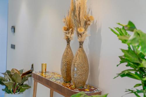 two vases sitting on a table with flowers in them at Villa Marrakech vue atlas in Marrakech