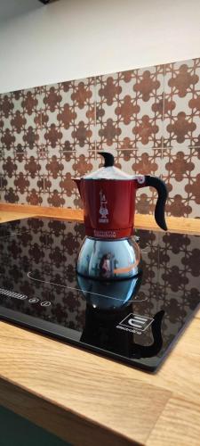a red tea pot sitting on top of a table at La Brignoletta Le Case del Dria Acquario suite in Genova