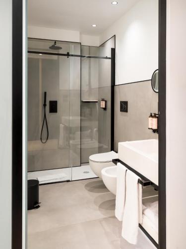 a bathroom with a shower and a toilet and a sink at Habita79 Hotel Pompeii - MGallery Collection in Pompei