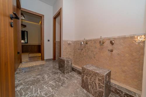 a bathroom with a walk in shower with a stone tile shower at Villa Marrakech vue atlas in Marrakech