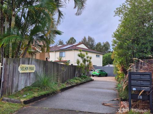a house with a wooden fence and a driveway at Nelson Parke in Yaroomba
