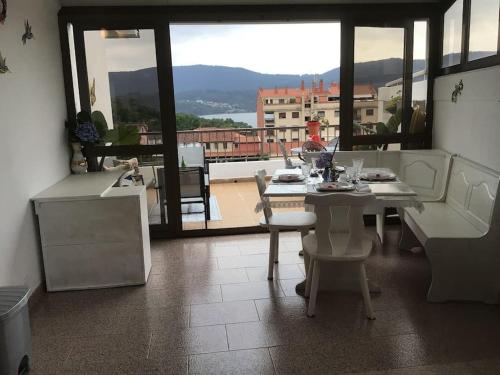 una mesa y sillas en una habitación con vistas en Villa Anuska, en Sotomayor