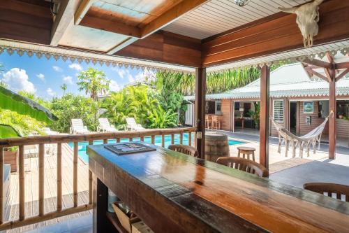 Anse-BertrandにあるVilla Catalunyaのプールと家の景色を望む屋外バー