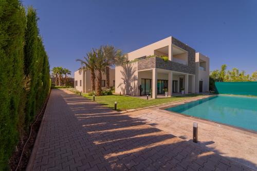 a villa with a swimming pool and a house at Villa Marrakech vue atlas in Marrakech