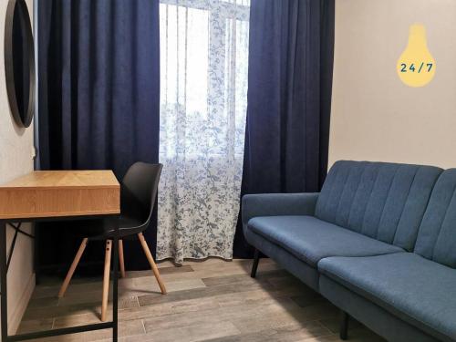 a living room with a blue couch and a window at Green Apartments in Chernihiv